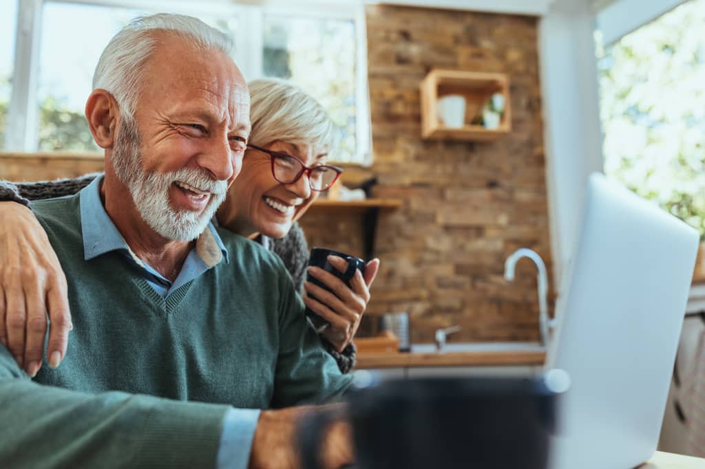 Older couple reviewing their free NHS health benefits paperwork at home in the UK