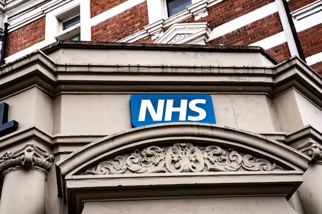 Exterior of a UK NHS GP practice building showing the NHS signage