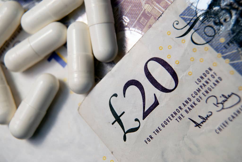 Pharmacist preparing a private prescription for a patient at a UK pharmacy counter
