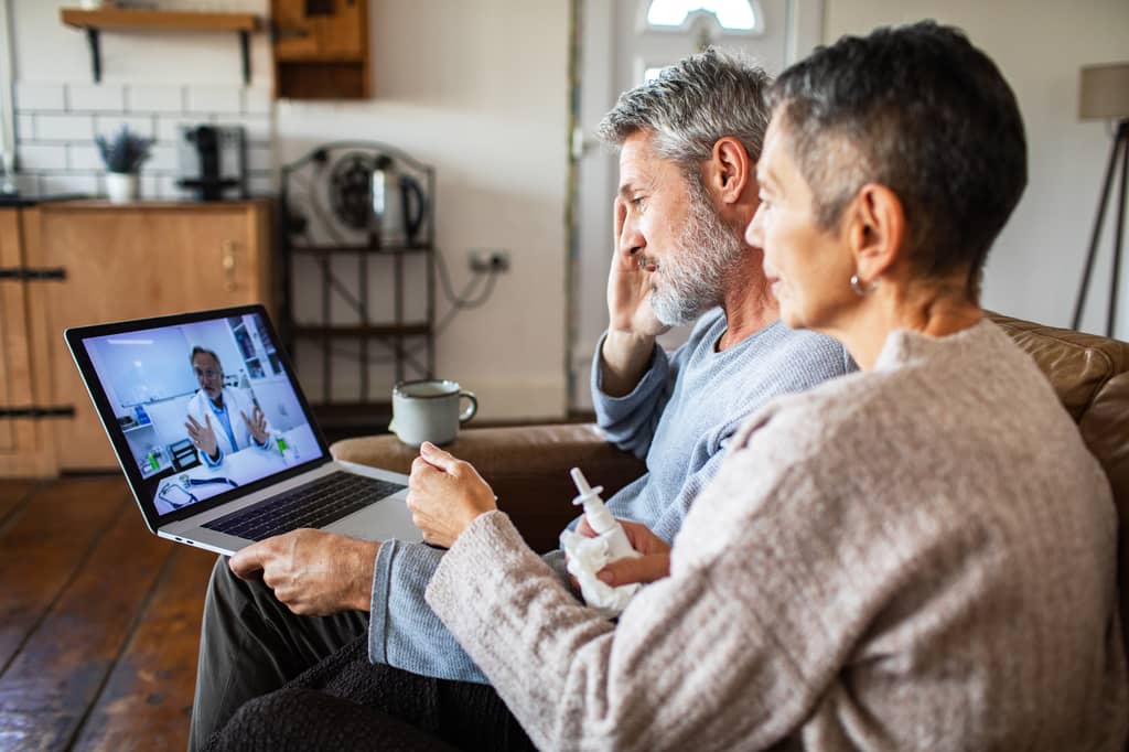 Patient consulting a GP through a video call on a laptop at home in the UK