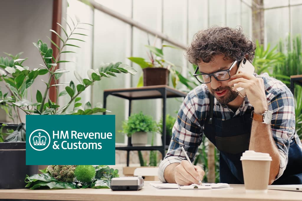 Man on the phone doing paperwork in a plant nursery, with the HMRC logo overlaid