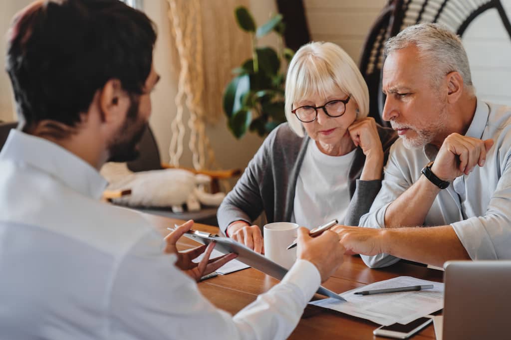 Adviser showing a senior couple a document to sign at a table