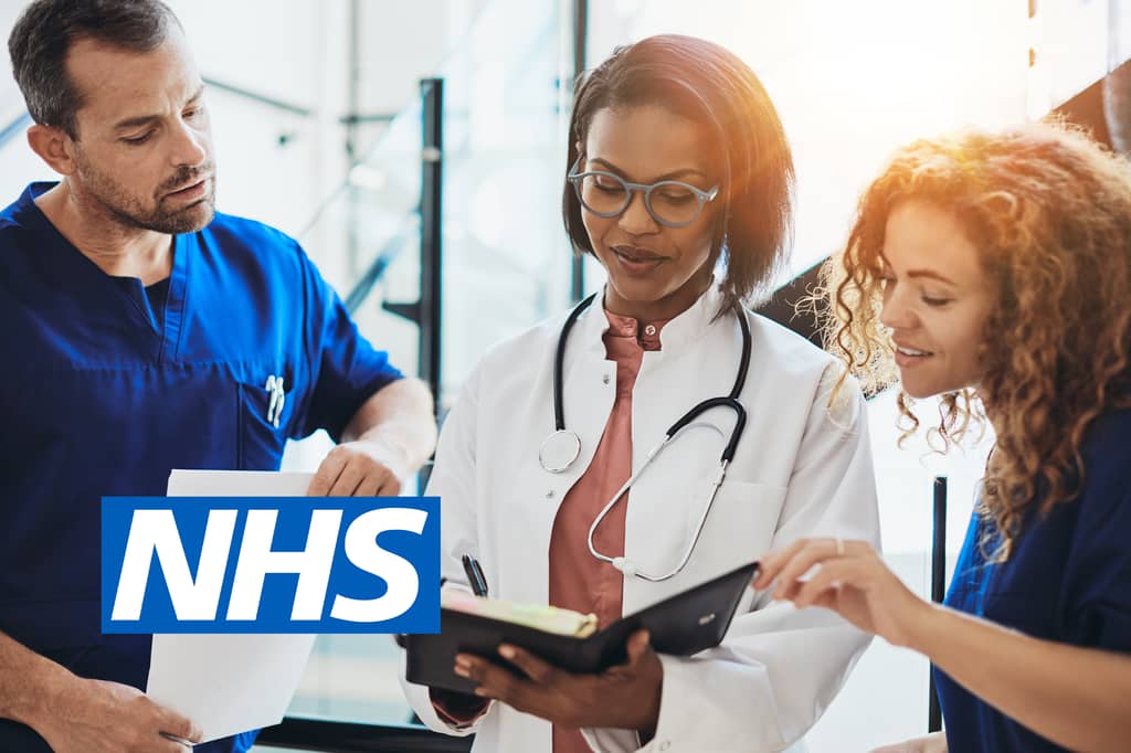 Three medical staff review notes together, with the NHS logo overlaid