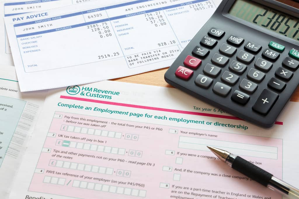 Person reviewing tax paperwork alongside a life insurance policy at home