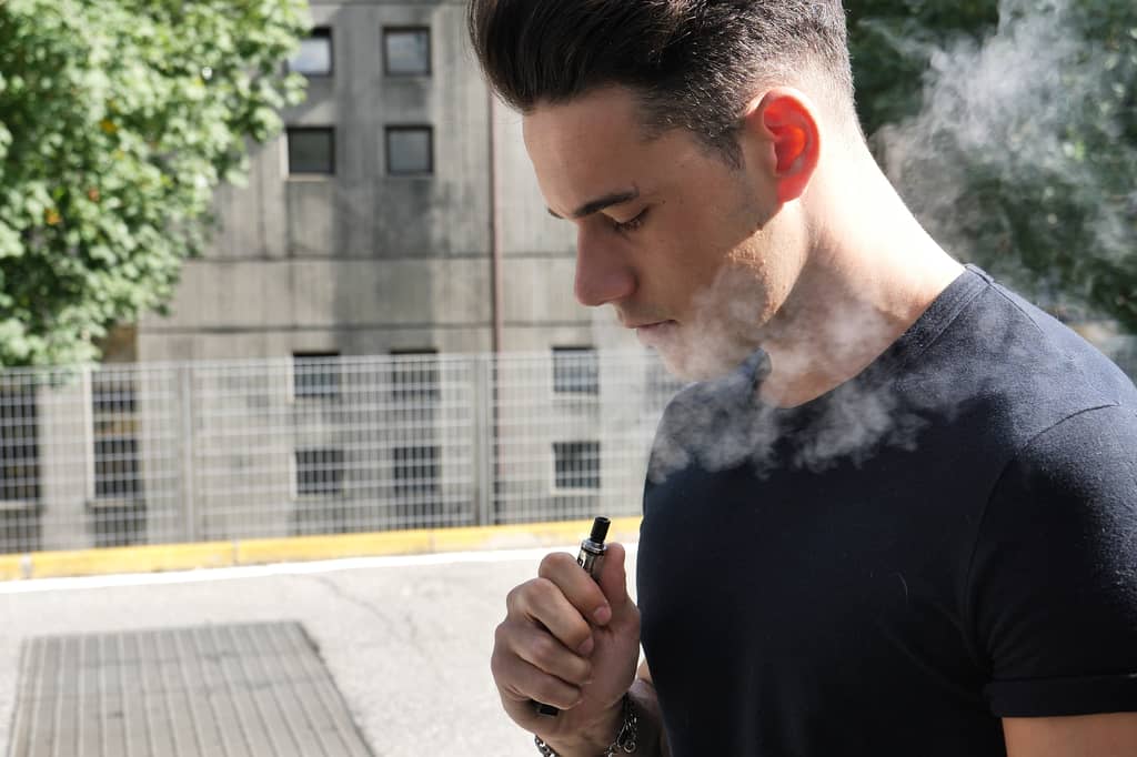 Person who smokes reviewing life insurance options and premiums at home